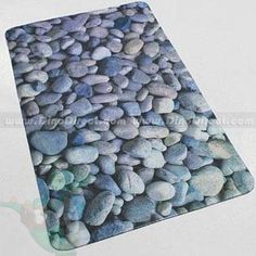 a place mat with rocks on it in blue and green colors, sitting on a white surface