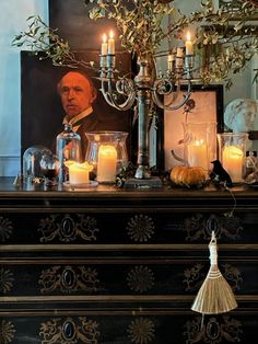 a dresser with candles and pictures on it