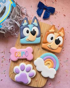 some decorated cookies on a wooden board with confetti