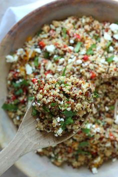 a wooden spoon filled with food on top of a table