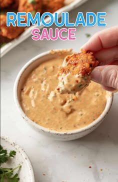 a hand dipping some food into a bowl