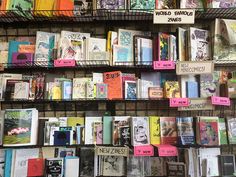 many books are on display in a book store with pink sticky notes attached to the shelves