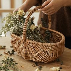 a woman is arranging flowers in a wicker basket