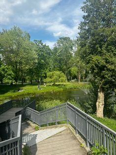 stairs lead down to a small pond in the middle of a park