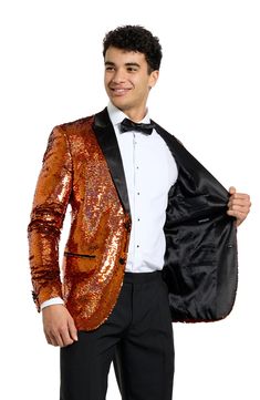 Drenched in golden sequins and finished with satin lapels, the jacket of this entrance-making tuxedo pairs with pleated black trousers and a coordinating bow tie to finish the standout look. Jacket has peaked lapels; four-button cuffs; chest pocket; welt pockets; interior pockets; side vents Trousers have zip fly with button-tab closure; slant pockets; back pockets Jacket is lined Unhemmed 100% polyester Machine wash, line dry Imported Party Suits With Sequins, Sequin Party Suits, Sequin Party Suits For Party Season, Glamorous Party Suit With Sequins, Glamorous Fitted Suits For Party, Gold Fitted Tuxedo For Formal Occasions, Glamorous Long Sleeve Party Suits, Fitted Sequin Blazer For Costume Party, Sequined Long Sleeve Suits For Night Out