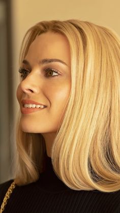 a woman with blonde hair is smiling for the camera