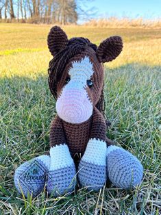 a crocheted stuffed animal sitting in the grass