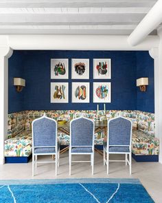 a living room with blue walls and white furniture in the corner, along with pictures on the wall