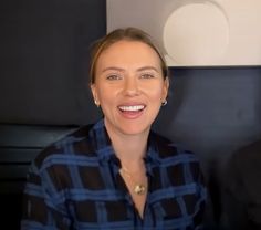 a woman sitting next to a man in a black and blue shirt smiling at the camera