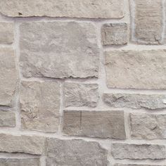 a brick wall that has been made out of various types of stones and is grey