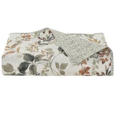 a white and brown floral print comforter with two pillows on the bottom, one is folded