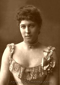 an old photo of a woman in a dress with flowers on her chest and shoulders