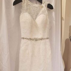 a white wedding dress hanging on a hanger