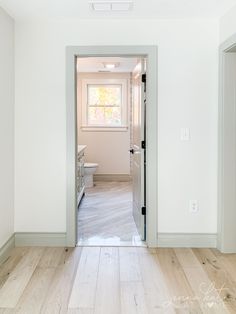 an empty room with white walls and wood flooring is seen from the entrance way