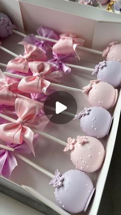 a box filled with lots of pink and purple cupcakes