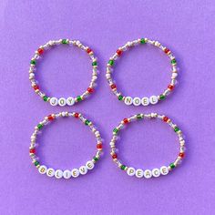 three bracelets with words on them and beaded in white, red, green and silver beads