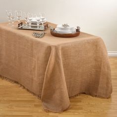 a table topped with plates and glasses on top of a wooden floor