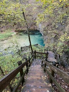 a wooden walkway leading to a waterfall in the woods