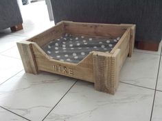 a dog bed made out of wood with polka dots on the top and bottom part