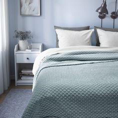 a bedroom with blue walls and white bedding