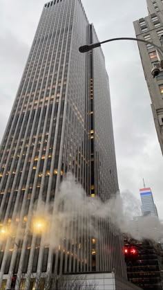 a tall building with lots of windows and fog coming out of the ground in front of it