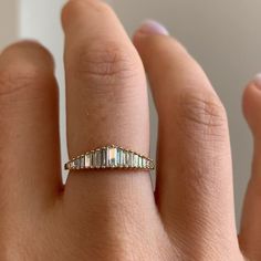 a woman's hand with a gold ring on it and three baguettes