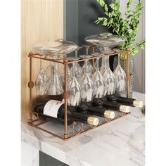 wine glasses and bottles are sitting on a rack in front of a marble counter top