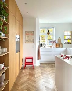 the kitchen is clean and ready to be used for cooking or baking, with white cabinets and wood flooring