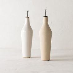 two white vases sitting next to each other on a table