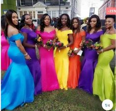 a group of women standing next to each other in long dresses and holding bouquets