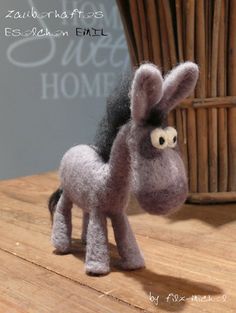 a small toy horse sitting on top of a wooden table