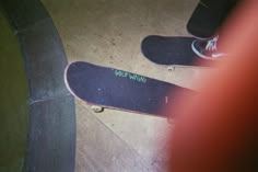 two skateboarders are standing on their boards at the top of a ramp and one is wearing white shoes