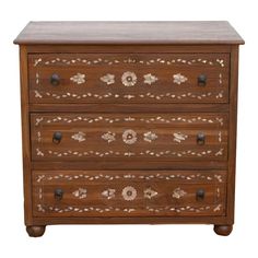 a wooden chest with two drawers on one side and an ornate design on the other