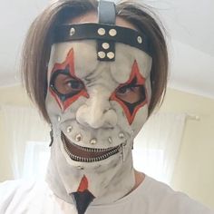 a man with his face painted to look like it is wearing a clown mask and tie