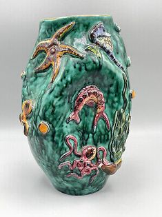 a green vase with sea creatures on it