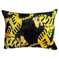 a black and yellow tiger pillow with pink flowers on it