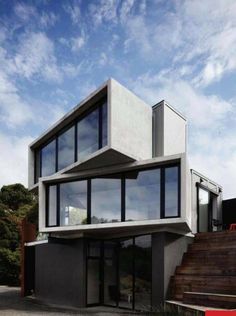 a modern house with large windows and wooden steps