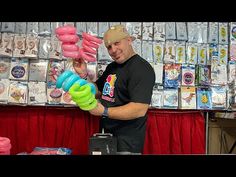 a man is holding up some balloons in front of a table with other items on it