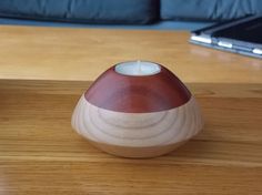 a small wooden candle holder sitting on top of a table next to a laptop computer