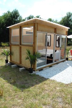 a small wooden cabin sitting on top of a grass covered field