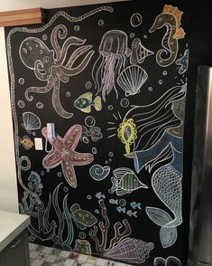 a chalkboard wall with sea animals and other marine creatures on it in a kitchen