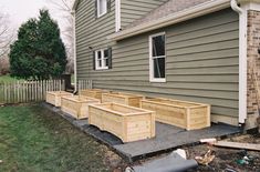 several wooden planters sitting in front of a house