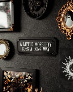 there are many framed pictures on the wall and one has a sign that says, a little morrbity goes a long way