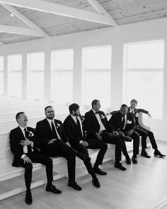 black and white photograph of men in suits sitting on a bench with their feet crossed