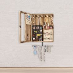 an open wooden jewelry box hanging on a wall