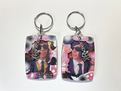 two key chains with pictures of people on them