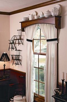 a living room filled with furniture and a large window covered in white drapes