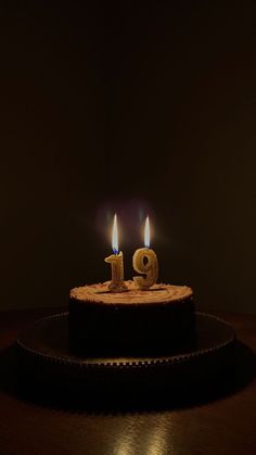 a birthday cake with two lit candles on it's top and the number nine