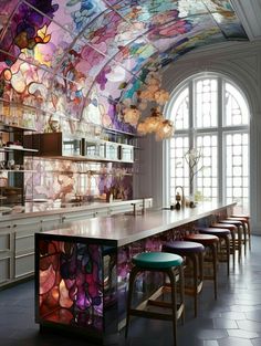 a large kitchen with lots of counter space and colorful ceiling tiles on the ceiling, along with bar stools