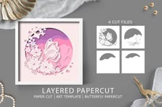 the layered papercut is displayed with scissors and other crafting supplies next to it